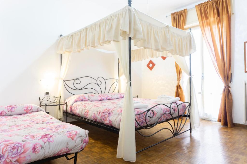 a bedroom with two beds and a canopy bed at Re Lear - 4 bedrooms Apartment in Verona