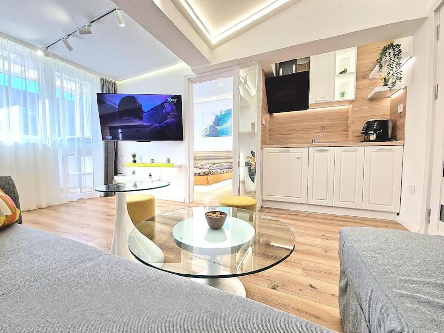 a living room with a glass table and a tv at Art Apartment + 2BD parking space in Varna City