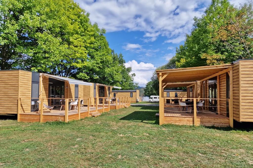 a row of wooden modular homes in a yard at Mobilna hiška Hupi in Velenje