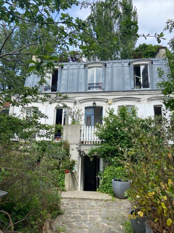 Casa blanca con balcón en la parte superior. en Le Grand Maulnes en París