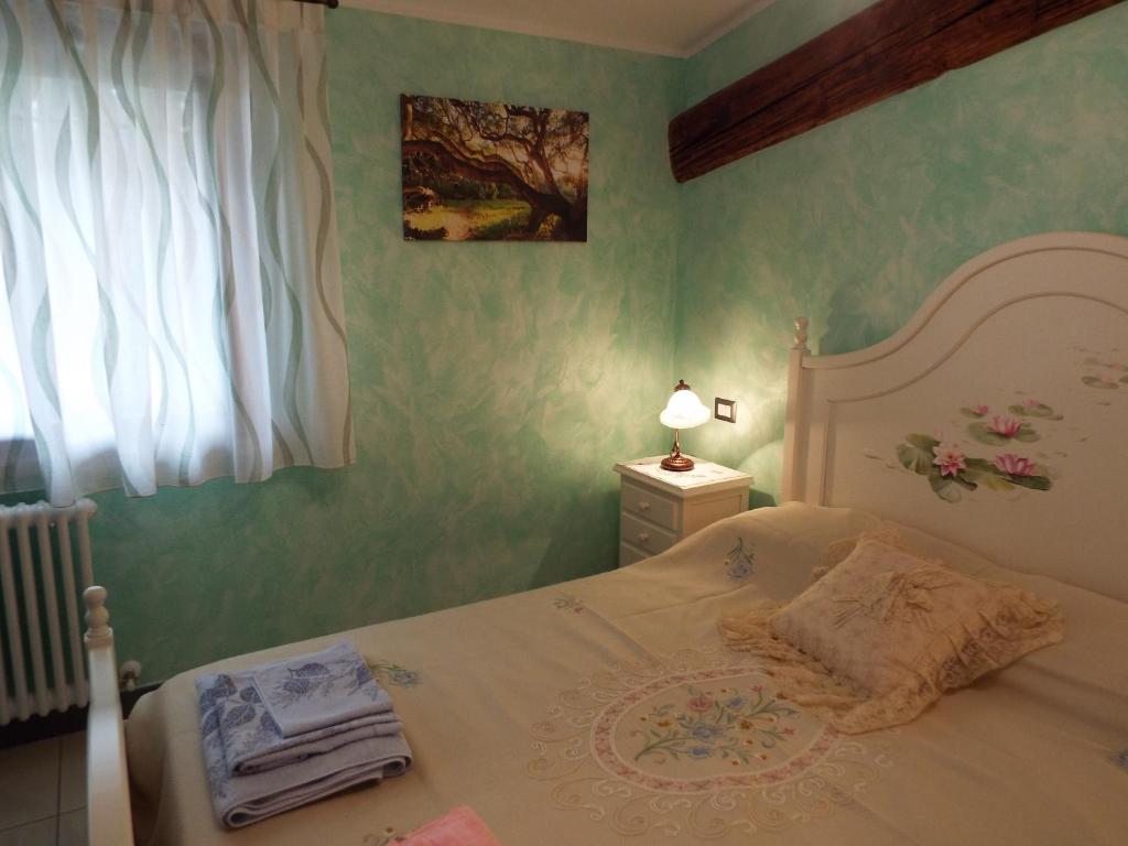 a bedroom with a white bed and a window at B&B Il Portico in Praticello di Gattatico