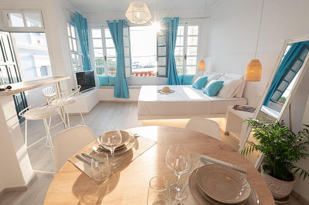 Sala de estar con cama y mesa de comedor en The White Rose Apartment, en Poros