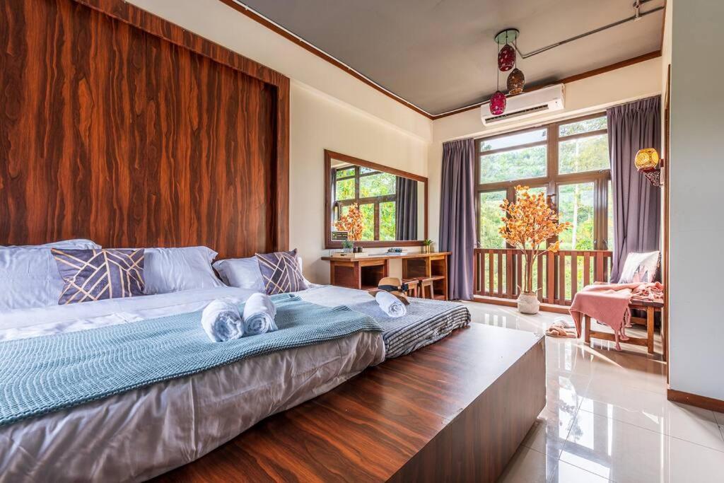Phòng ngủ homestay có giường lớn và ban công nhìn ra cây xanh