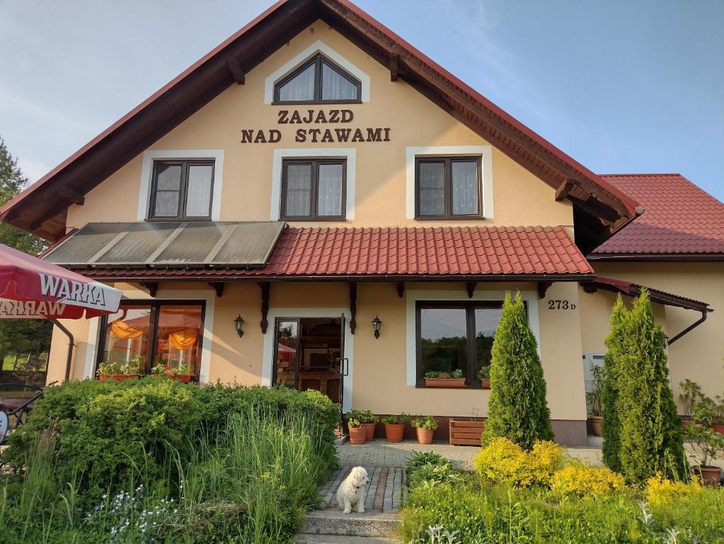 a building with a dog in front of it at Zajazd nad stawami in Uherce Mineralne (7)