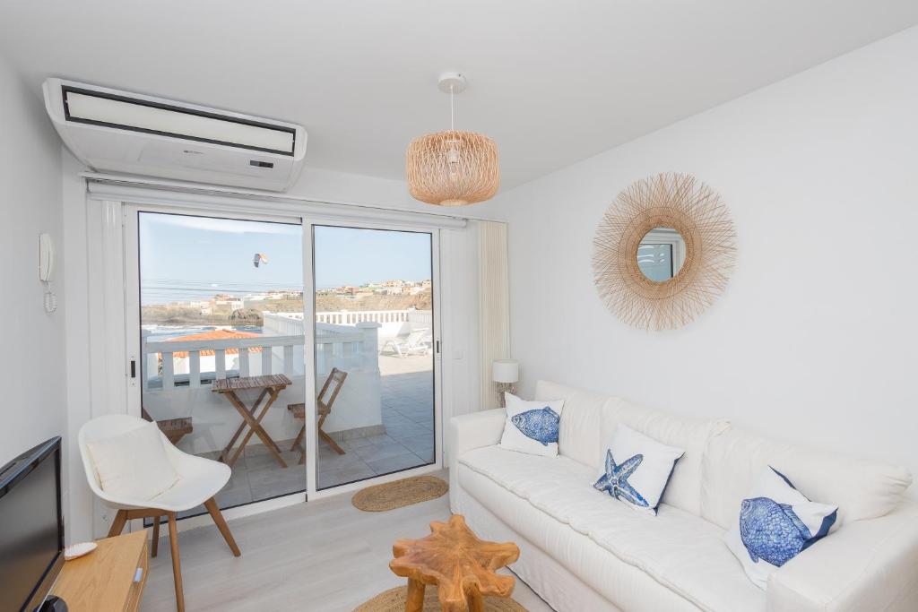 a white living room with a white couch and a window at Sea Views Private Terrace 2BR House near the Beach in Telde