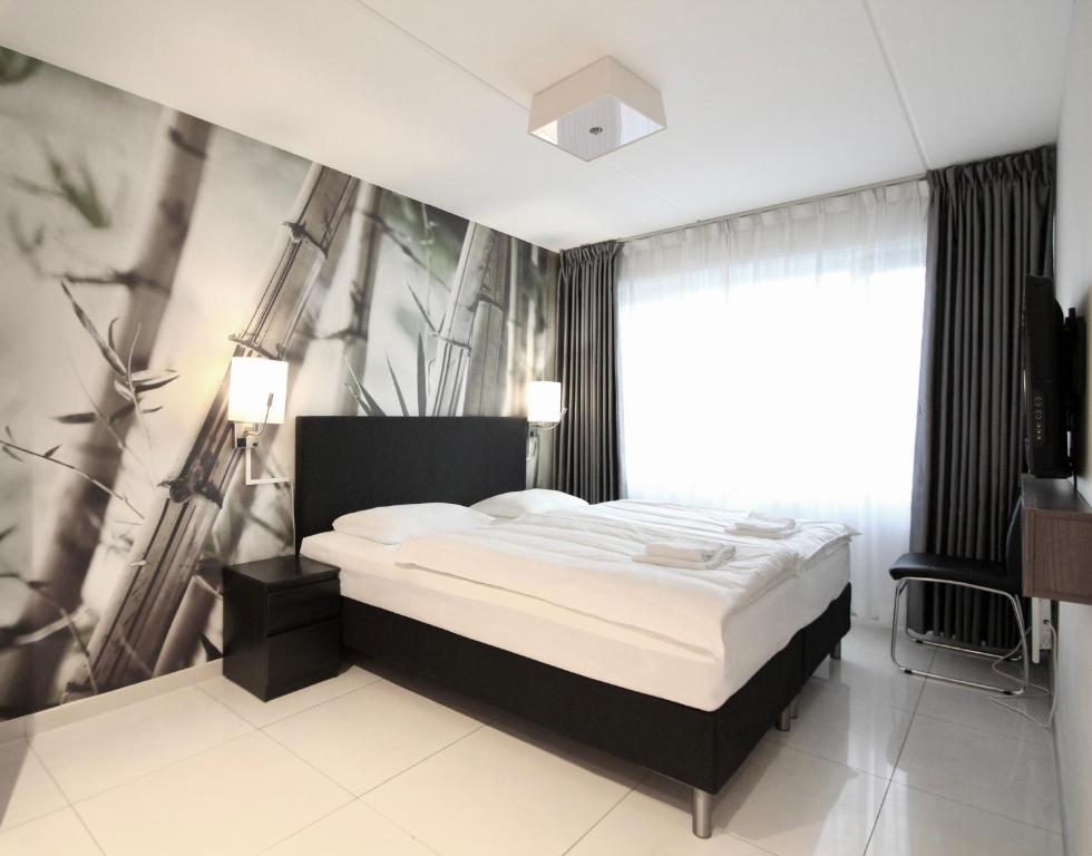 1 dormitorio con cama y ventana grande en Super Stay Hotel, Oslo en Oslo