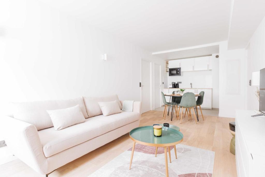 a white living room with a white couch and a table at Amazing Appartement - 6P2BDR - La DéfensePuteaux in Puteaux