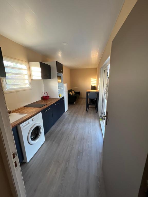 a kitchen with a washer and dryer in a room at Logement en pleine nature, à 15min du centre ville in Kourou