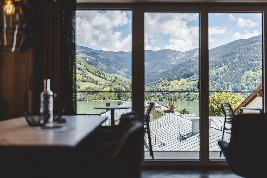 a room with a large window with a view of a lake at The Gast House Zell am See in Zell am See