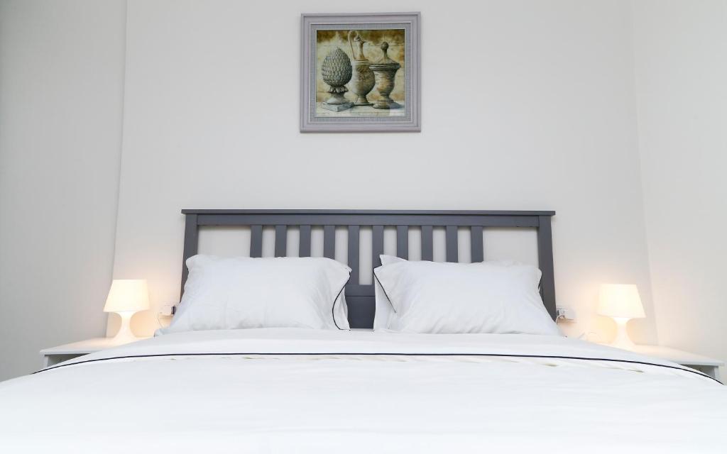 - un lit blanc avec 2 oreillers blancs et 2 lampes dans l'établissement Porto Said Tourist Resort Luxury Hotel Apartment, à Port-Saïd