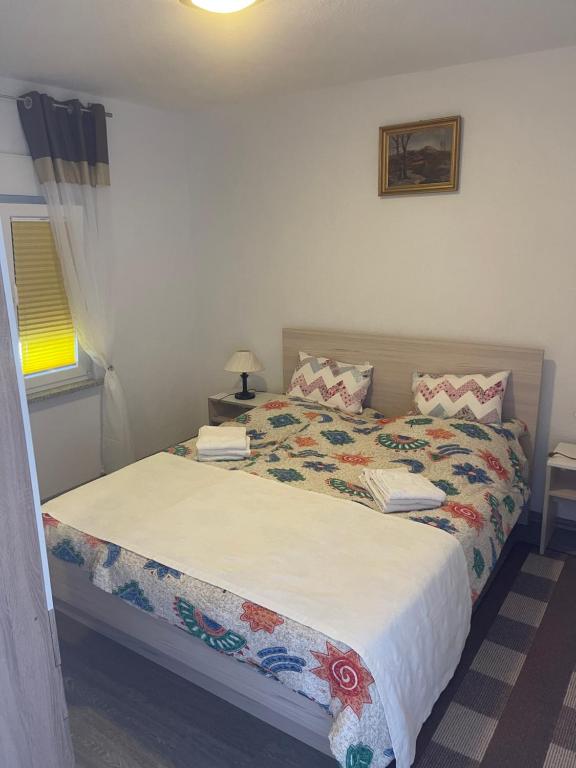 a bedroom with a bed with a white bedspread at Apartments Marija in Vir