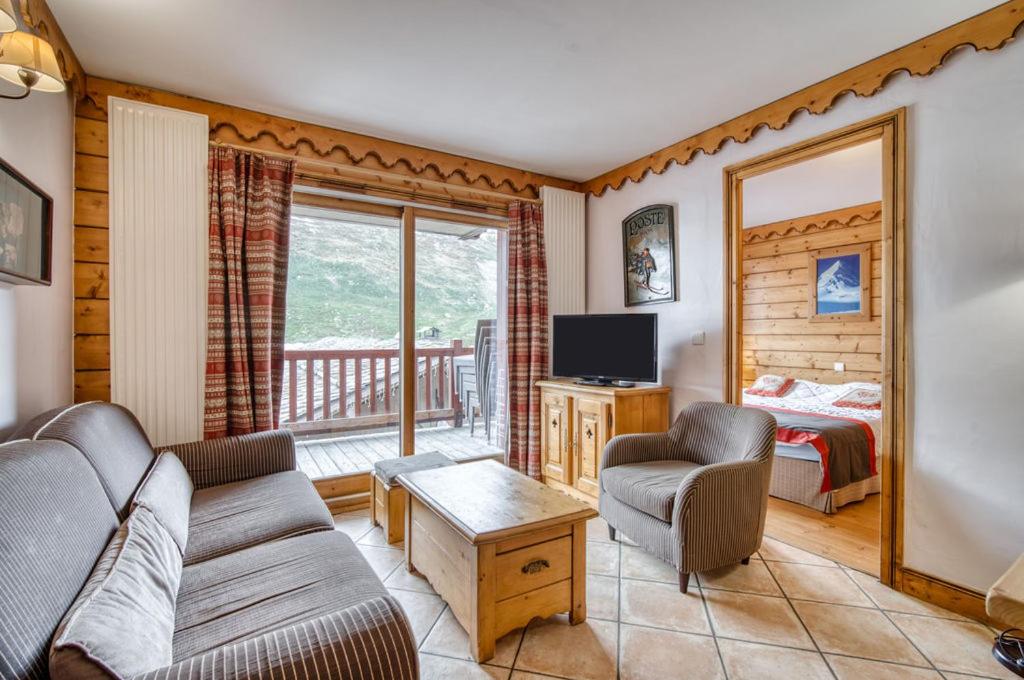 uma sala de estar com um sofá, uma televisão e uma cama em Appartments in Tignes Ecrin des Neiges em Tignes