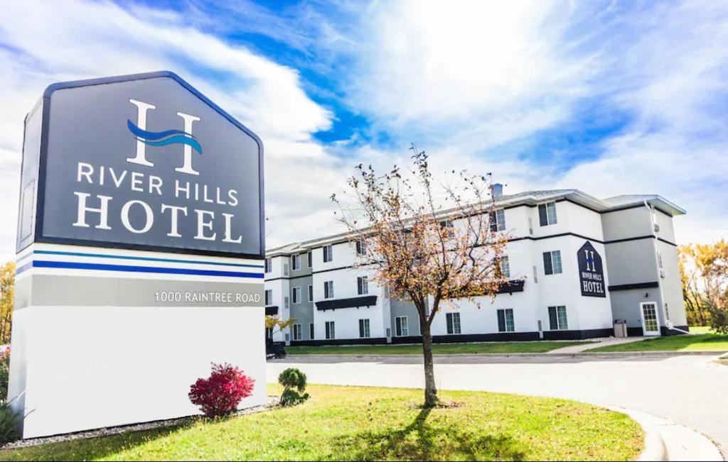um sinal para um hotel River Hills em frente a um edifício em River Hills Hotel- Mankato em Mankato