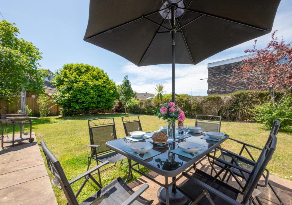 a table with an umbrella on a patio at Preston Down in Paignton