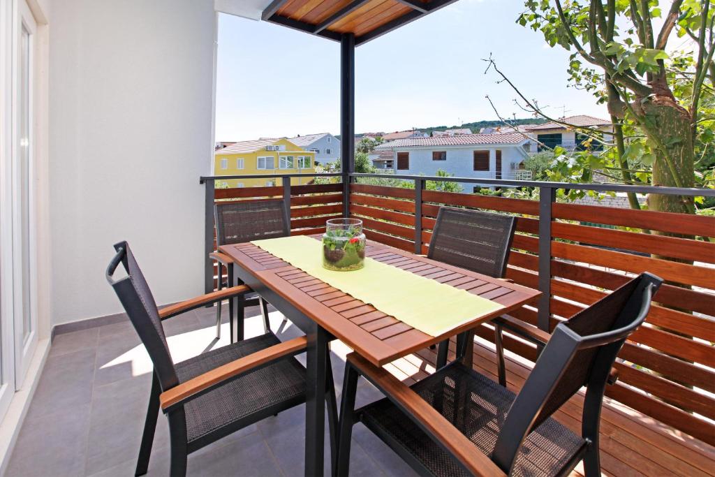 a wooden table and chairs on a balcony at Santa Cruz Apartments Supetar in Supetar