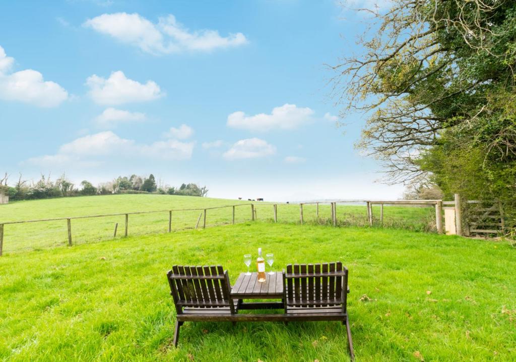 a table with two chairs in a field at Rydon Ball in Abbotskerswell