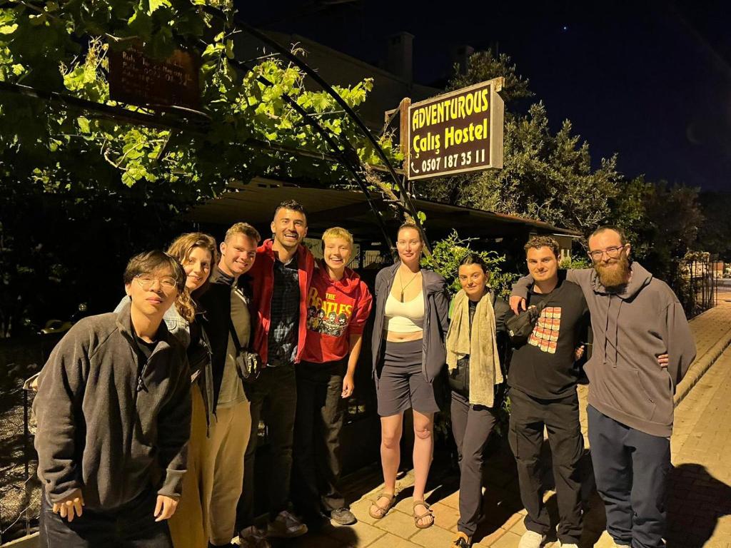 a group of people posing for a picture in front of a sign at Adventurous Local Hostel in Fethiye
