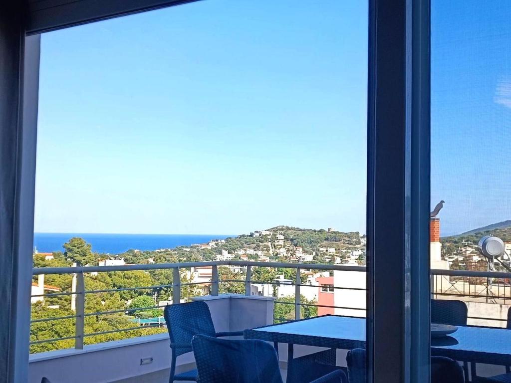 balcón con mesa y vistas al océano en Petros House Artemis - Near the Airport, en Artemida