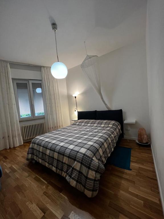 1 dormitorio con 1 cama con manta a cuadros en Bianchelli Affittacamere, en Iesi