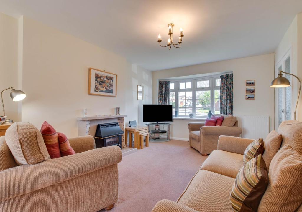 a living room with two couches and a television at Farthings in Salcombe Regis