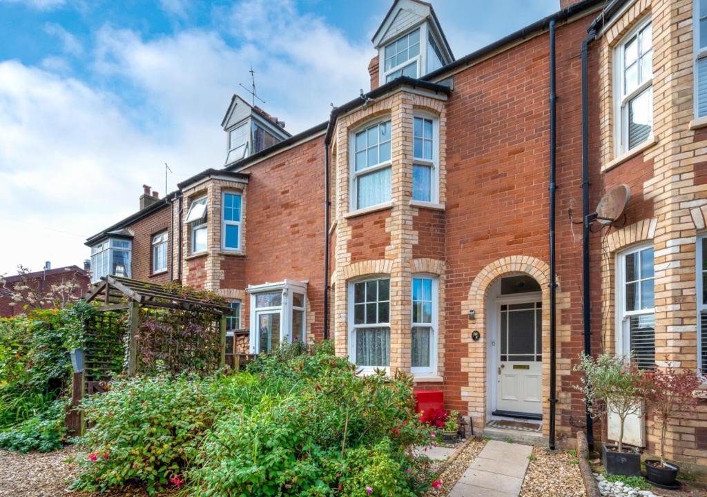 a red brick house with a white door at Glenisla in Sidmouth