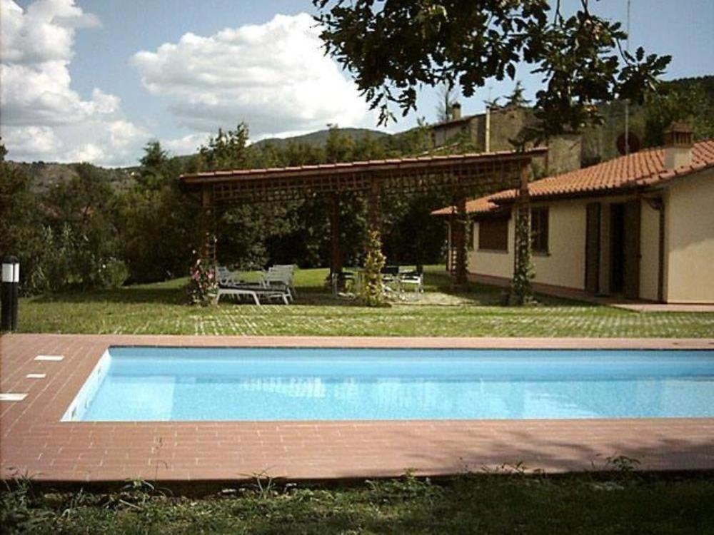 a swimming pool in front of a house at Villa Paola in Arezzo