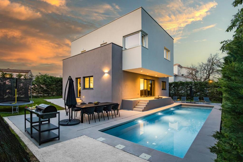 uma villa com piscina em frente a uma casa em Villa Aida - 4 bedroom luxury villa with large private pool 4K projector and Jacuzzi em Pula