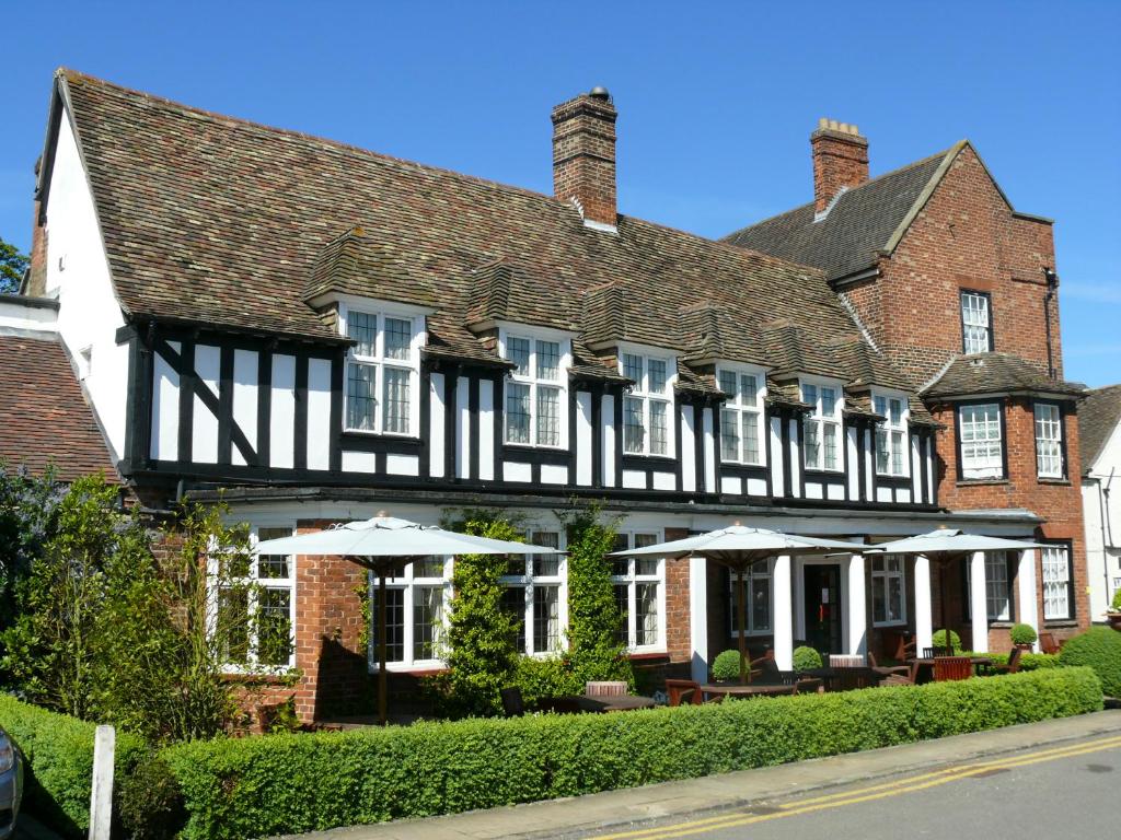 a large brick building with umbrellas in front of it at The George Hotel in Buckden