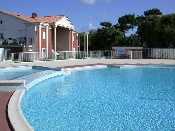 a large blue swimming pool in front of a house at L'Hollywood Zen in Saint-Jean-de-Monts