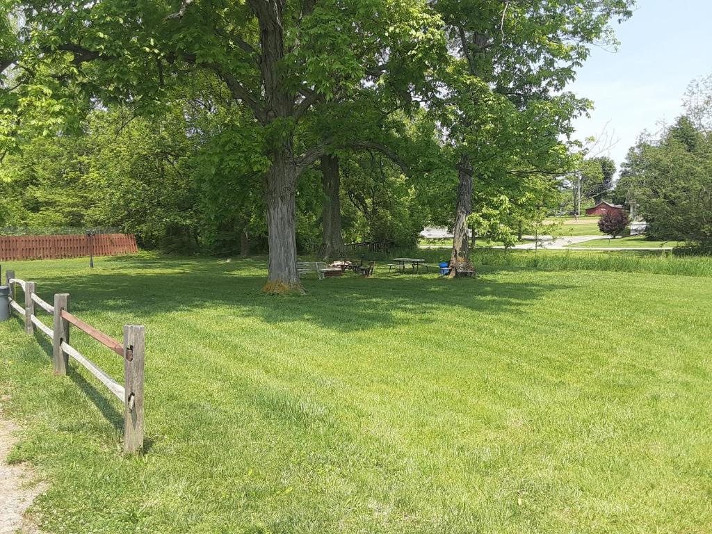 una valla de madera en un campo con un árbol en HICKORY SHADES MOTEL en Nashville