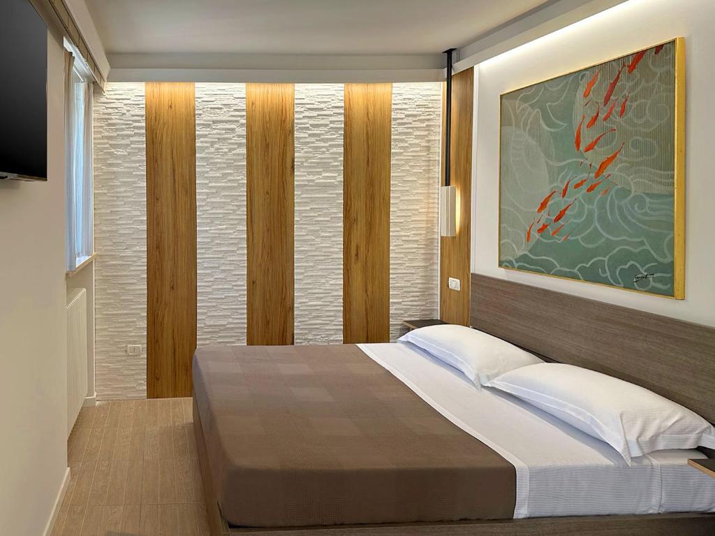 ein Schlafzimmer mit einem Bett und einem Wandgemälde in der Unterkunft La Residenza di Opera Arte in Numana