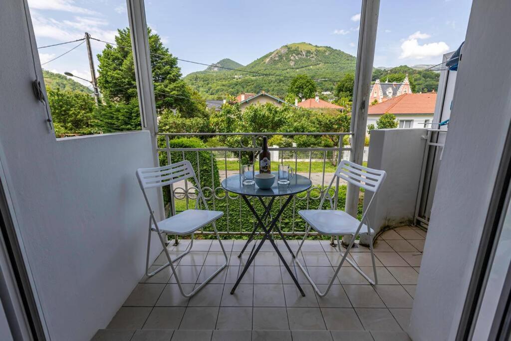 d'un balcon avec une table et deux chaises et une vue. dans l'établissement joli appartement T2 près du parc thermal, à Argelès-Gazost