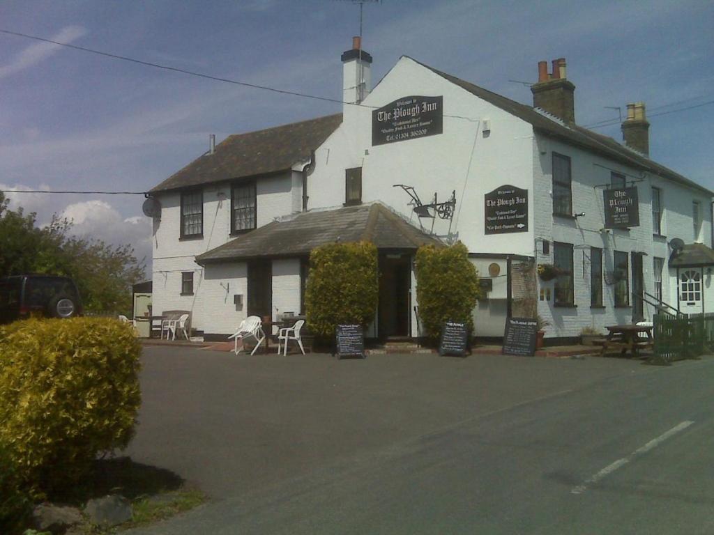 a white building with tables and chairs in front of it at The Plough Inn Ripple in Deal