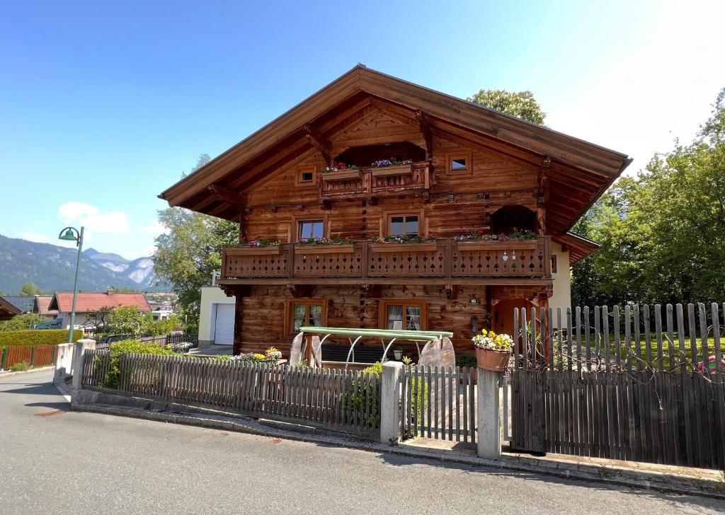 a wooden house with a fence in front of it at Appartement am Mühlrain in Saalfelden am Steinernen Meer