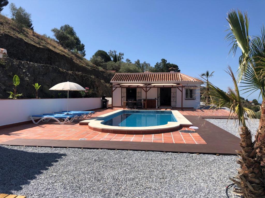 a backyard with a pool and a house at Panoramavilla Lofio Spain in Cómpeta