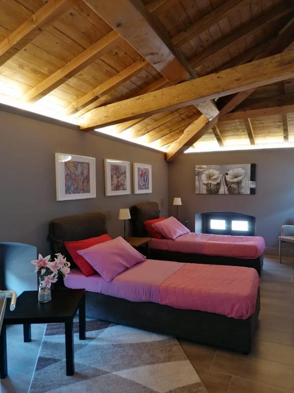 two beds in a living room with wooden ceilings at A Casa Mia - Catania Apartment in Catania