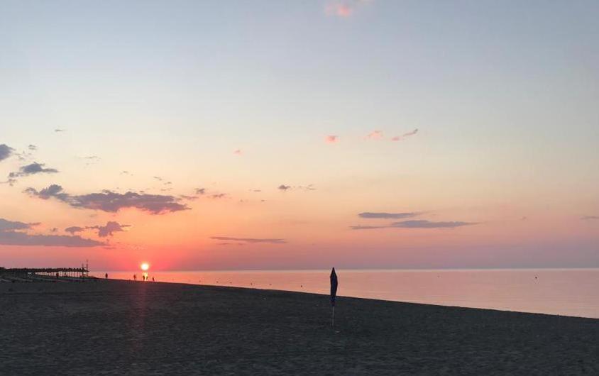 una persona in piedi sulla spiaggia al tramonto di La Porta Del Sole a Nova Siri Marina