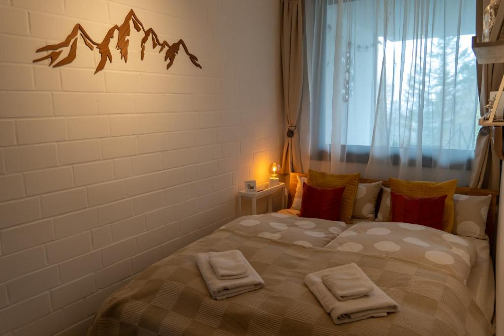 1 dormitorio con 1 cama con 2 toallas en FeWo Harzer Weitblick Hunde Willkommen, W Lan, 2x Smart TV en Braunlage