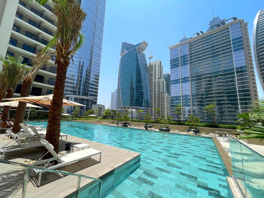 una piscina con palmeras y edificios en CitiHome- Business Bay, en Dubái