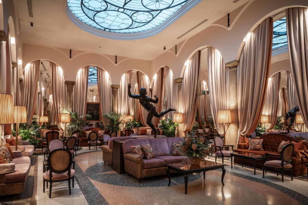 a lobby with couches and a stained glass window at Grand Hotel et de Milan - The Leading Hotels of the World in Milan