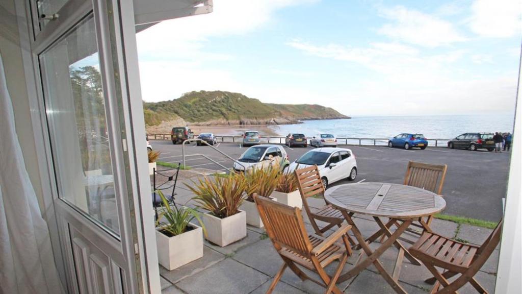 a patio with a table and chairs and a view of the ocean at Redcliffe Apartments A in Bishopston