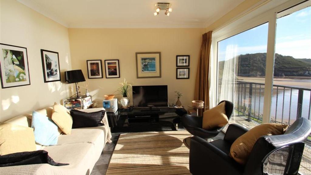 een woonkamer met een bank en stoelen en een balkon bij Redcliffe Apartments C in Bishopston