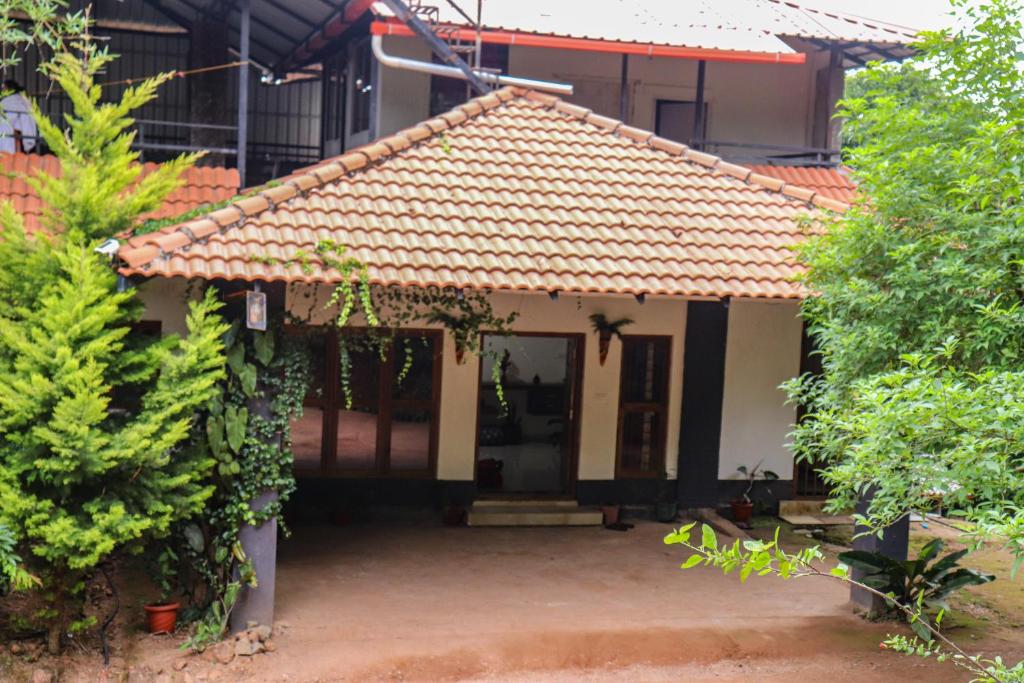 a small house with an orange tile roof at Coorg Nature Breeze Homestay in Madikeri
