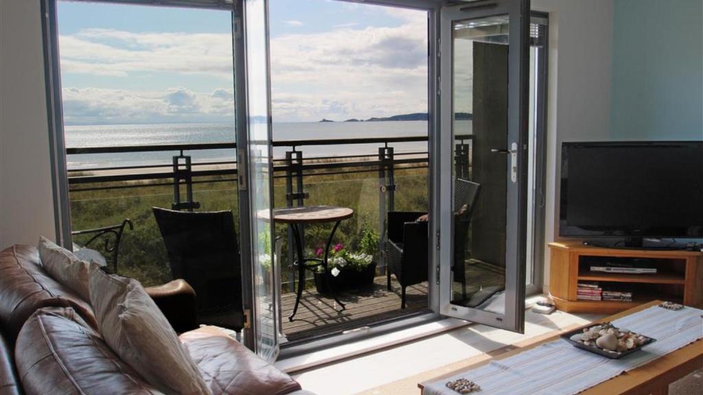 a living room with a view of the ocean at Fishermans Way in Swansea