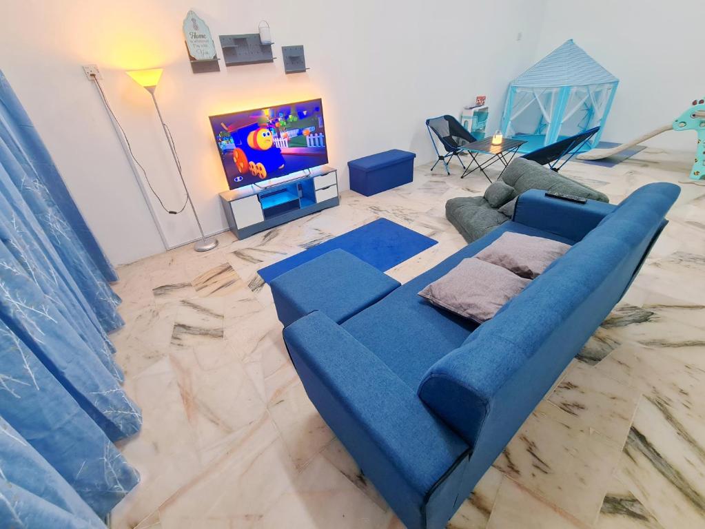 a blue couch in a living room with a tv at 611 Navy House Seremban Homestay Seremban Town in Seremban