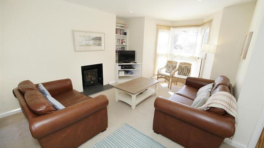ein Wohnzimmer mit 2 Sofas und einem Kamin in der Unterkunft Westbourne Place in The Mumbles