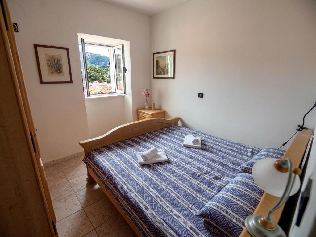 - une chambre avec un lit et 2 serviettes dans l'établissement Luise - Four Towers Apartments, à Rab