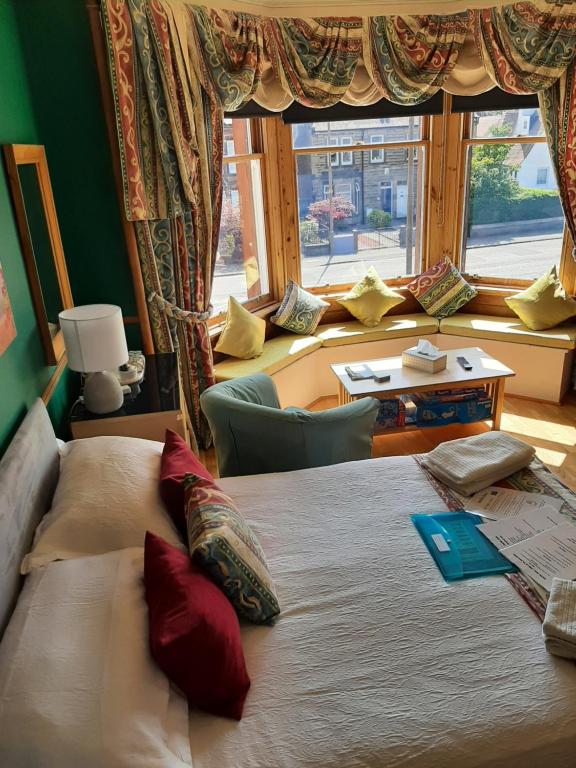 um quarto com uma cama grande e uma janela grande em Another Room em Edimburgo