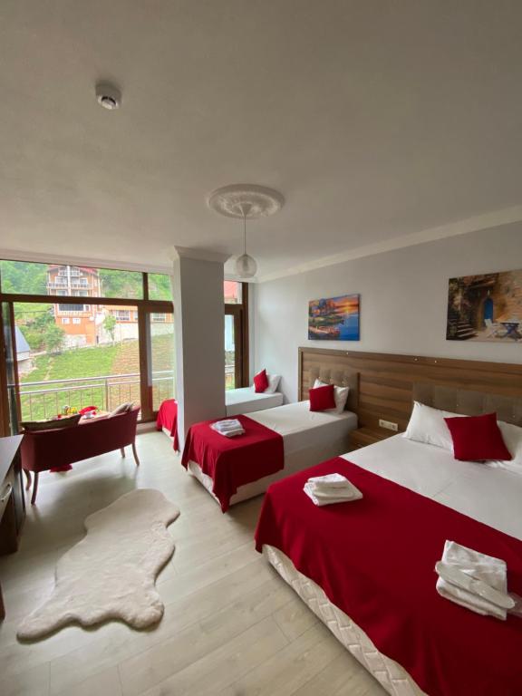 a bedroom with two beds and a couch and a desk at Vadidekal Suite Hotel in Çamlıhemşin
