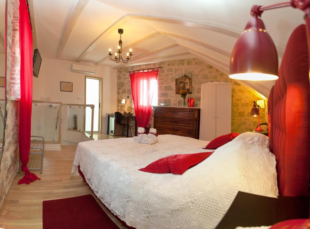a bedroom with a large bed with red curtains at Bed & Breakfast Vila Baguc in Split